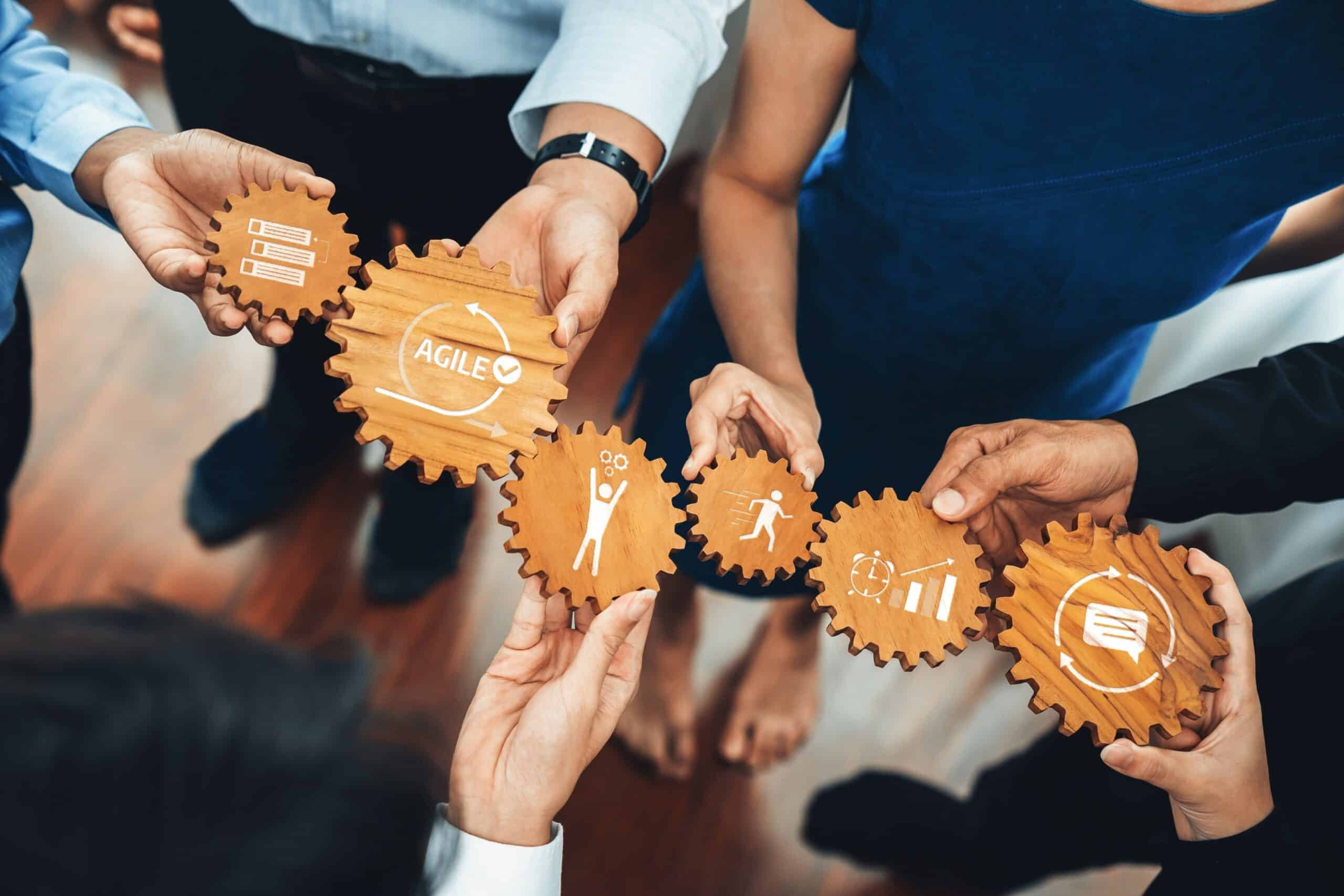 Un groupe d'individus tenant des engrenages avec des symboles agile